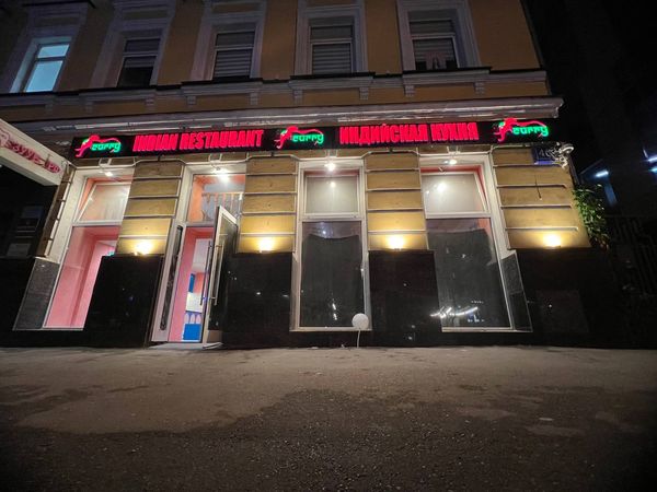 Фасад индийского ресторана со световыми вывесками вечером