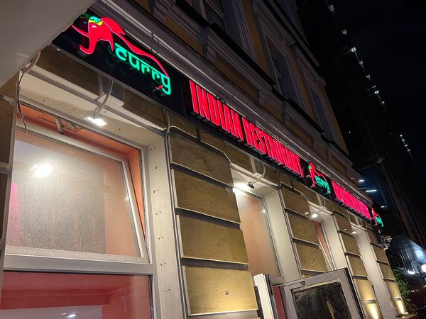 Угловая световая вывеска ресторана ночью